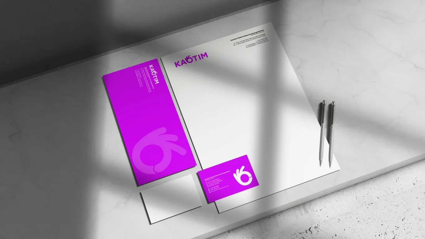 Kaotim stationery suite with letterhead, business card and pens arranged on a marble surface